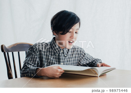 机で本を読む男子 98975446