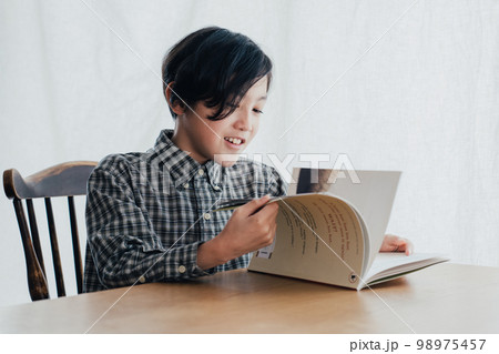 机で本を読む男子 98975457