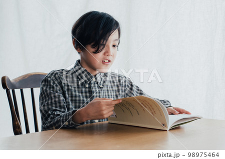 机で本を読む男子 98975464