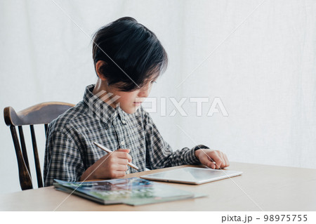 机で勉強する男子 98975755