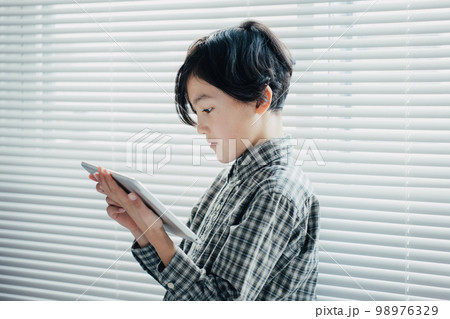 タブレットに夢中な男子 98976329