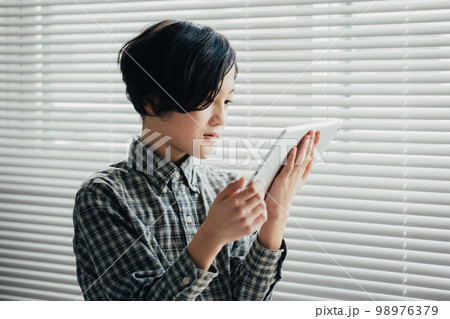 タブレットに夢中な男子 98976379