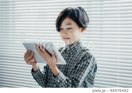 タブレットに夢中な男子 98976482