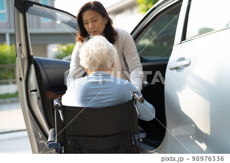 Asian senior or elderly old lady woman patient sitting on wheelchair prepare get to her car, healthy strong medical concept. Asian senior or elderly old lady woman patient sitting on wheelchair prepare get to her car, healthy strong medical concept. 98976536