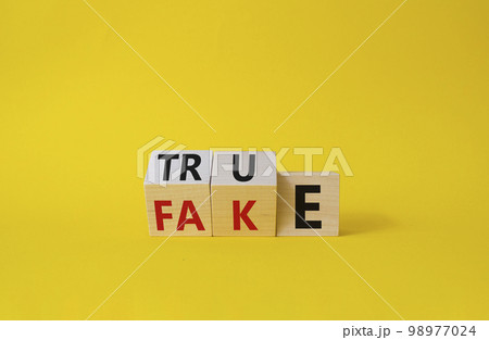True vs Fake symbol. Wooden cubes with words Fake and True. Beautiful yellow background. Business and True vs Fake concept. Copy space 98977024