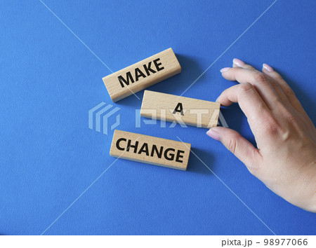 Make a change symbol. Concept words Make a change on wooden blocks. Beautiful blue background. Businessman hand. Business and Make a change concept. Copy space. 98977066