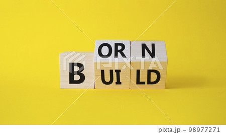 Born and Build symbol. Turned wooden cubes with words Build to Born. Beautiful yellow background. Business and Born and Build concept. Copy space. 98977271