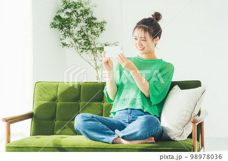 スマホで動画を観る女性 スマホで動画を観る女性 98978036