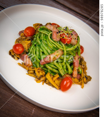 Recipe for spaghetti with spinach cream and smoked bacon, tomatoes and chanterelle mushrooms 98978285