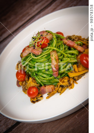 Recipe for spaghetti with spinach cream and smoked bacon, tomatoes and chanterelle mushrooms 98978358