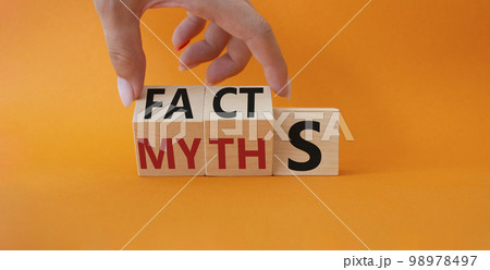 Facts vs Myths symbol. Businessman Hand turns cubes and changes word Myths to Facts. Beautiful orange background. Business and Facts vs Myths concept. Copy space 98978497