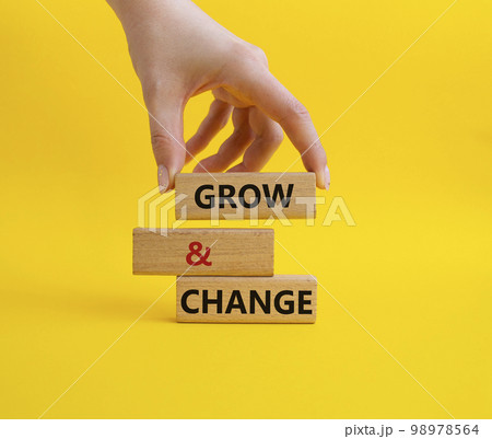 Grow and Change symbol. Concept word Grow and Change on wooden blocks. Businessman hand. Beautiful yellow background. Business and Grow and Change concept. Copy space 98978564