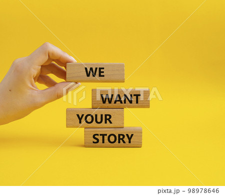 We want your story symbol. Concept words We want your story on wooden blocks. Beautiful yellow background. Businessman hand. Business and We want your story concept. Copy space. 98978646