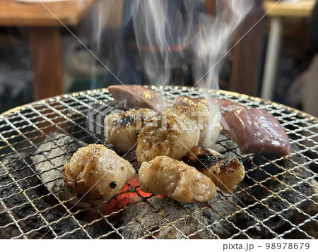 ホルモンを焼く（上に伸びる煙） 98978679