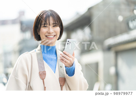 スマートフォンを持つ女性、旅行、観光、一人旅、笑顔、カメラ、撮影、記念写真、成人女性、タブレット 98979977