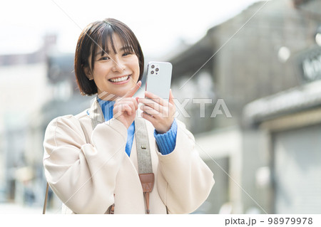 スマートフォンを持つ女性、旅行、観光、一人旅、笑顔、カメラ、撮影、記念写真、成人女性、タブレット 98979978