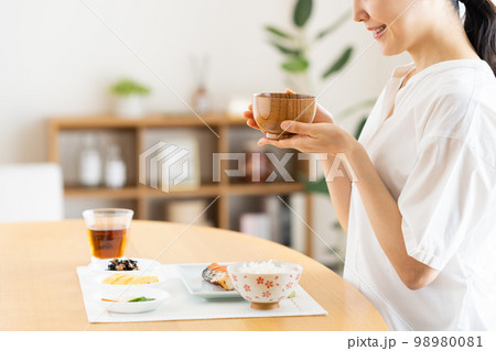 朝ごはんを食べる若い女性 98980081