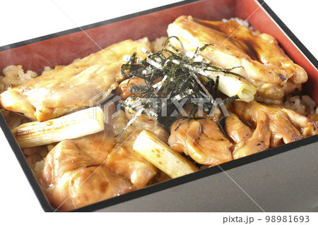 タレがたっぷりかかった熱々炭火焼き鳥重を白背景で撮影 98981693