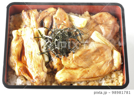 タレがたっぷりかかった熱々炭火焼き鳥重を白背景で俯瞰撮影 98981781