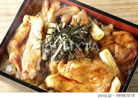 タレがたっぷりかかった熱々炭火焼き鳥重を俯瞰で撮影 タレがたっぷりかかった熱々炭火焼き鳥重を俯瞰で撮影 98982078
