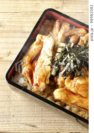 タレがたっぷりかかった熱々炭火焼き鳥重を俯瞰で撮影 98982082