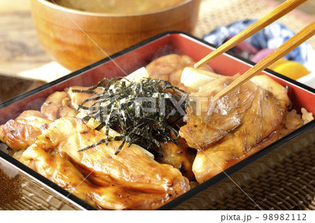 タレがたっぷりかかった熱々の炭火焼き鳥重と味噌汁とお漬物 98982112