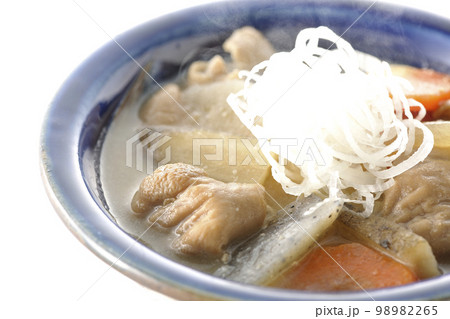 人参、蒟蒻、牛蒡、大根の入った熱々の豚もつ煮込みを白背景で撮影 98982265