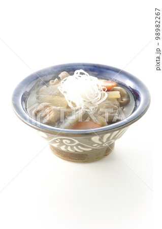 人参、蒟蒻、牛蒡、大根の入った熱々の豚もつ煮込みを白背景で撮影 98982267