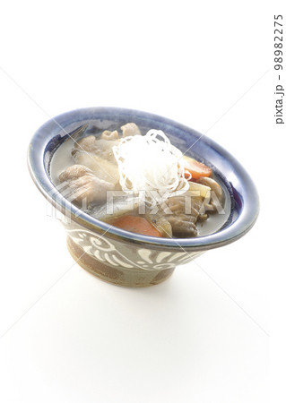 人参、蒟蒻、牛蒡、大根の入った熱々の豚もつ煮込みを白背景で撮影 98982275