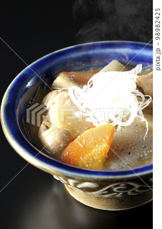 人参、蒟蒻、牛蒡、大根の入った熱々豚もつ煮込みを黒背景で撮影 人参、蒟蒻、牛蒡、大根の入った熱々豚もつ煮込みを黒背景で撮影 98982425