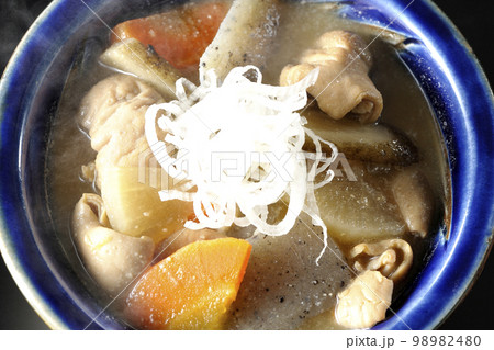 人参、蒟蒻、牛蒡、大根の入った熱々豚もつ煮込みを黒背景で俯瞰撮影 98982480