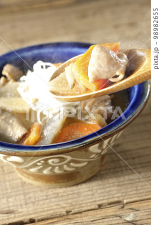 人参、蒟蒻、牛蒡、大根の入った熱々の豚もつ煮込みを食べる 98982655