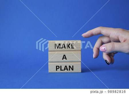 Make a plan symbol. Concept word Make a plan on wooden blocks. Businessman hand. Beautiful blue background. Business and Make a plan concept. Copy space Make a plan symbol. Concept word Make a plan on wooden blocks. Businessman hand. Beautiful blue background. Business and Make a plan concept. Copy space 98982816