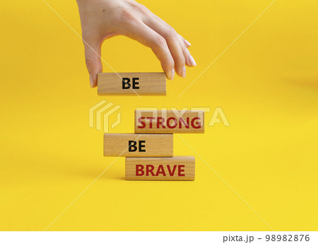 Be strong be brave symbol. Concept words Be strong be brave on wooden blocks. Beautiful yellow background. Businessman hand. Business concept. Copy space. Be strong be brave symbol. Concept words Be strong be brave on wooden blocks. Beautiful yellow background. Businessman hand. Business concept. Copy space. 98982876