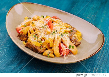 Fettuccine pasta with beef, chicken and parmesan Fettuccine pasta with beef, chicken and parmesan 98983035