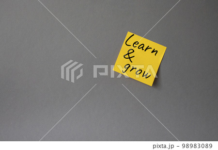 Learn and grow symbol. Concept words Learn and grow on orange steaky note. Beautiful grey background. Business and Learn and grow concept. Copy space. 98983089