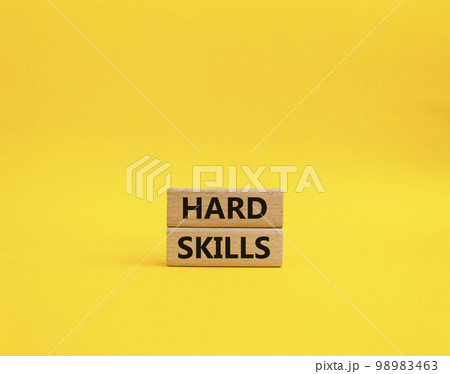 Hard skills symbol. Wooden blocks with words Hard skills. Beautiful yellow background. Businessman hand. Business and Hard skills concept. Copy space 98983463
