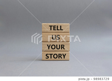 Tell us your story symbol. Concept words Tell us your story on wooden blocks. Beautiful grey background. Business and Tell us your story concept. Copy space. 98983729