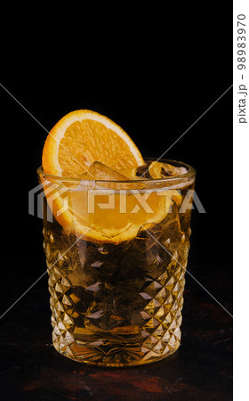 Old-fashioned cocktail with ice and orange slice Old-fashioned cocktail with ice and orange slice 98983970
