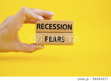 Recession fears symbol. Concept words Recession fears on wooden blocks. Beautiful yellow background. Businessman hand. Business and Recession fears concept. Copy space. 98984657