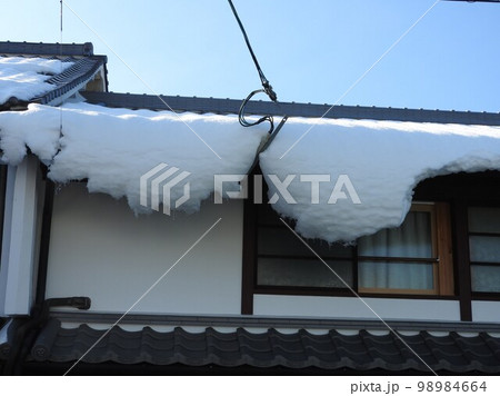 屋根からずれて垂れ下がる雪庇 98984664