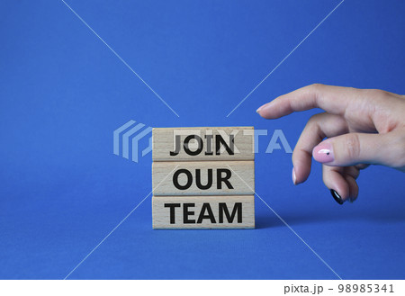 Join our team symbol. Wooden blocks with words Join our team. Beautiful blue background. Businessman hand. Business and Join our team concept. Copy space. 98985341