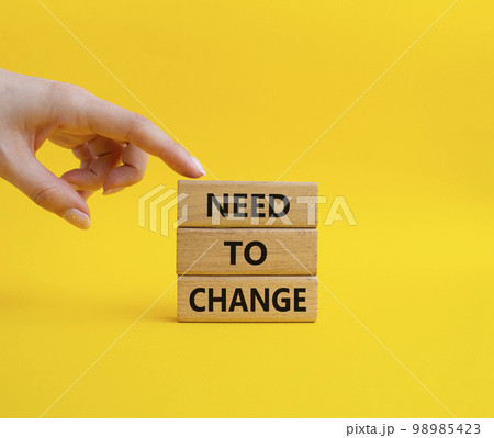 Need to change symbol. Concept words 'Need to change' on wooden blocks. Beautiful yellow background. Businessman hand. Business and Need to change concept. Copy space. 98985423