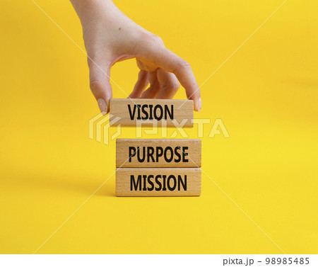 Vision Purpose Mission symbol. Concept word Vision Purpose Mission on wooden blocks. Beautiful yellow background. Businessman hand. Business and Vision Purpose Mission concept. Copy space. 98985485