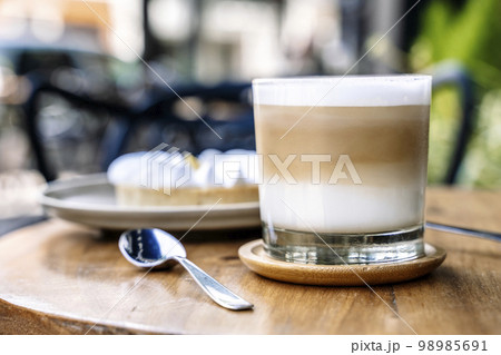 Coffee and cake on a cafe table outside. Morning, drink, good mood concept Coffee and cake on a cafe table outside. Morning, drink, good mood concept 98985691