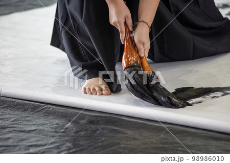 半紙に力強く文字を書く女子高生 98986010