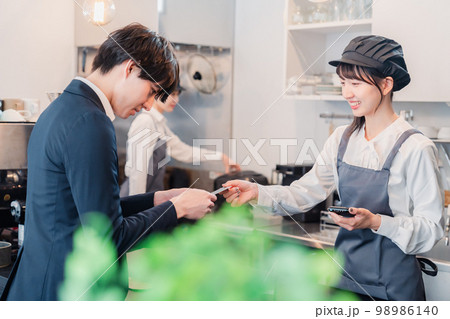 カフェでクレジット決済をするビジネスマン 98986140