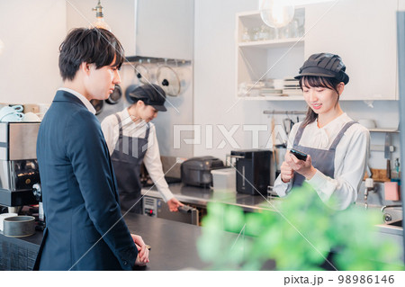 カフェでクレジット決済をするビジネスマン 98986146