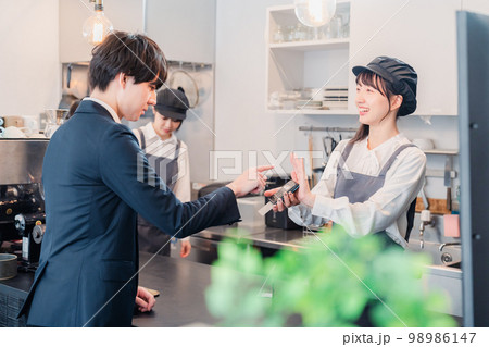 カフェでクレジット決済をするビジネスマン 98986147