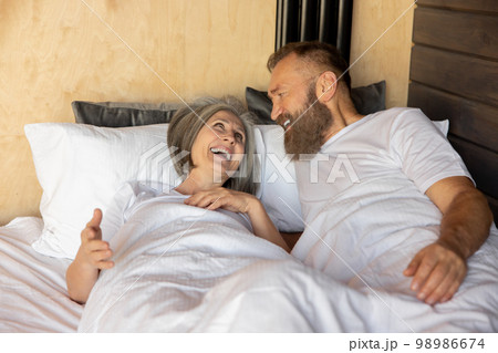 Mature couple staying in bed and looking happy 98986674